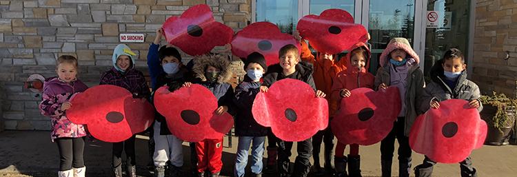 students holding giant poppies